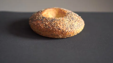 Round bread bun with sesame and poppy seeds macro loop video Video stock 318844488
