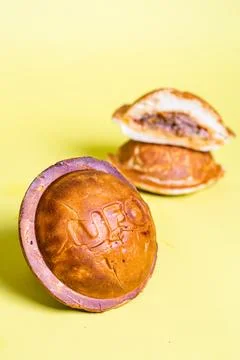 Round bread roll with UFO imprint, isolated on yellow background, split roll  Stock Photos