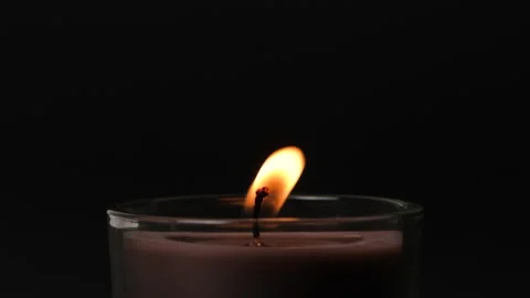 Round brown single Candle flickering in the dark. Side view. Candle in glass Stock Footage 207865039