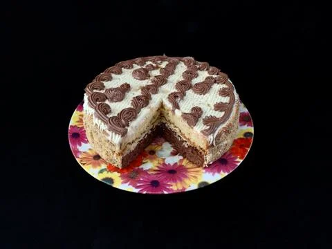 Round cake with cream patterns, on a black background. A sweet birthday prese Stock Photos