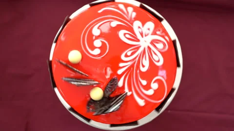 Round cake made of red chocolate with a white pattern Vidéo 234825697
