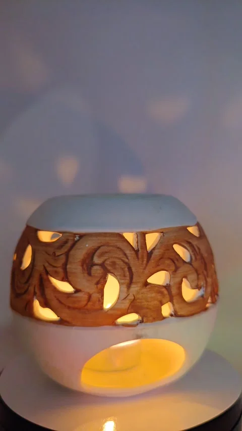 A round candlestick with a beautiful ornament burns close-up Видео 330132620