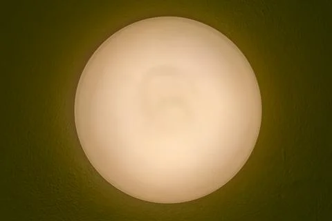 Round ceiling lamp emitting warm light Stock Photos