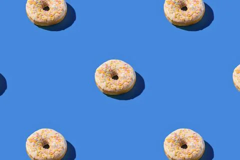 Round cereal rings arranged in a pattern on a blue background Stock Photos