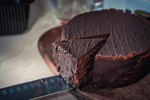 Round chocolate cake with triangular slice cut off Stock Photos