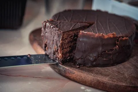 Round chocolate cake with triangular slice cut off Stock Photos