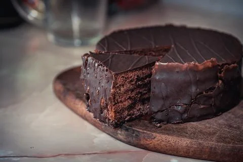 Round chocolate cake with triangular slice cut off Stockfoto's