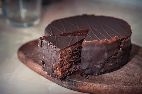 Round chocolate cake with triangular slice cut off Stockfoto's