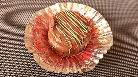 Round chocolate cookie with green and red icing drizzle topping Stock Photos