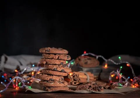 Round chocolate cookies in a stack, around the New Year's burning garlands Stock-Fotos