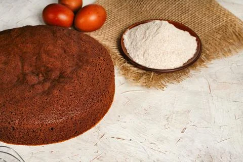 A round chocolate sponge cake or chiffon cake on baking paper so soft and Stock Photos