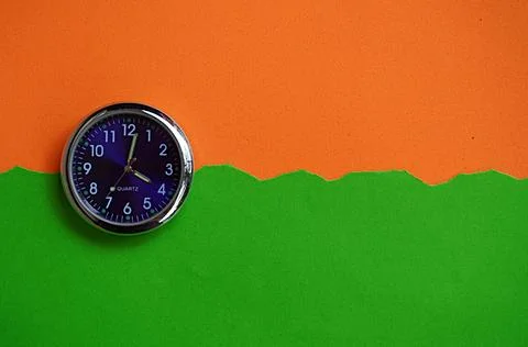 Round clock with a combination of orange green colors. Large space for text 写真素材