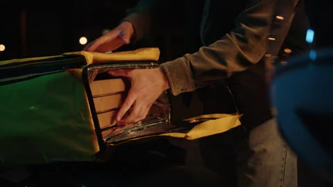 Round-the-clock delivery. The courier takes out pizza boxes from a thermos bag Видео 265063615