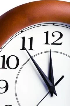 Round clock showing time about twelve isolated Stock Photos