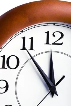 Round clock showing time about twelve isolated Stock Photos