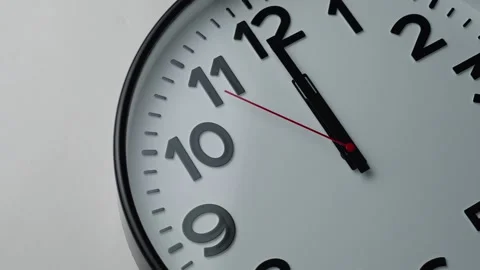 Round clock shows one minute to twelve, close-up. Classic clock time and Ne.. Stock Footage 293697787