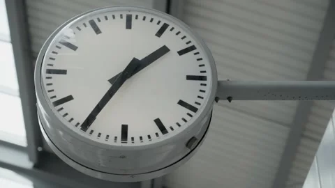 Round clock at a train station showing the time Видео 278316049