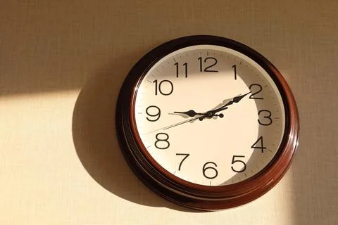 Round clock with a white dial on the wall Stock Photos