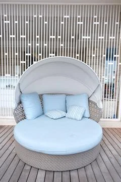 Round comfortable sofa with blue bed linen. Stock Photos