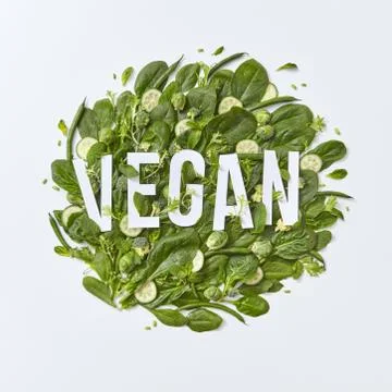 Round composition of different green vegetables with vegan paper lettering on a Fotos de archivo