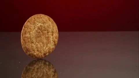 Round cookie spinning on dark reflective surface Stock Footage 327121188