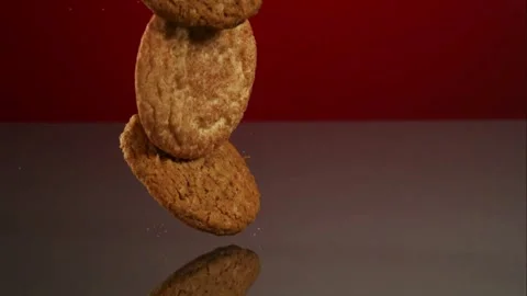Round cookies fall and bounce on a dark surface Stock Footage 327786749