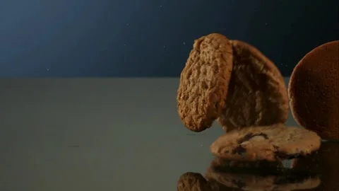 Round cookies falling on a reflective surface Stock Footage 327120633