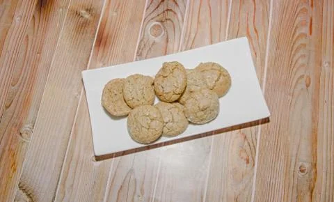 Round cookies stack on a white plate, powder sugar, wood background Foto stock