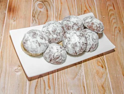 Round cookies stack on a white plate, powder sugar, wood background Foto stock