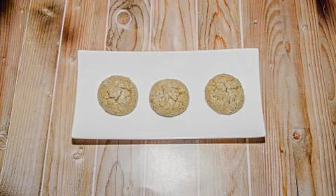 Round cookies stack on a white plate, powder sugar, wood background Stock Photos