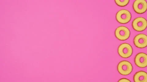 Round cookies in two columns move on right side of pink theme. Stop motion Stock-Footage 169658742