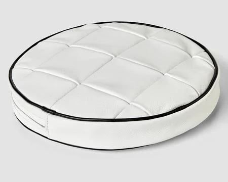 Round cushion in white patchwork leather with contrasting black trim 写真素材