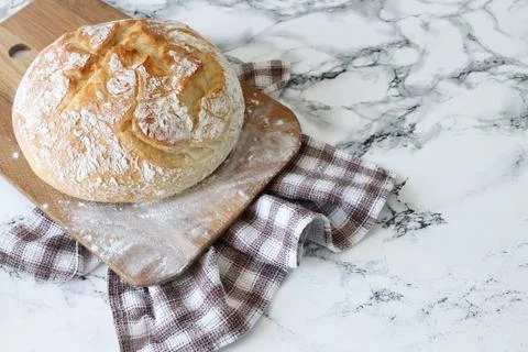 Round cut rye bread for slicing on wooden rustic board with flour Stock Photos