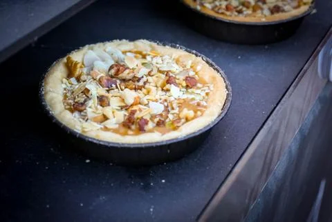 Round dessert with nuts, on a dark background. Stock Photos