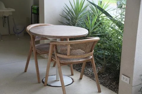 A round dining table with two chairs, in the garden of an apartment buildin.. Stock Photos