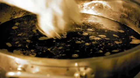 Round dough in a hot pan with boiling cooking oil Stock Footage 65554682