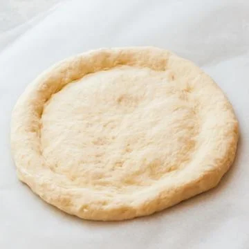Round dough on a table, preparing ramadan pide. Stock Photos