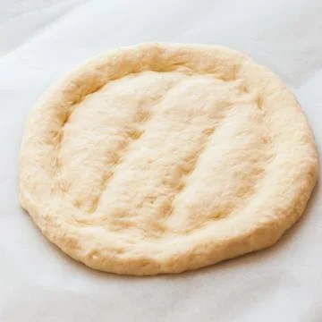 Round dough on a table, preparing ramadan pide. Stock Photos