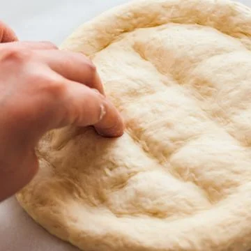 Round dough on a table, preparing ramadan pide. Stock Photos