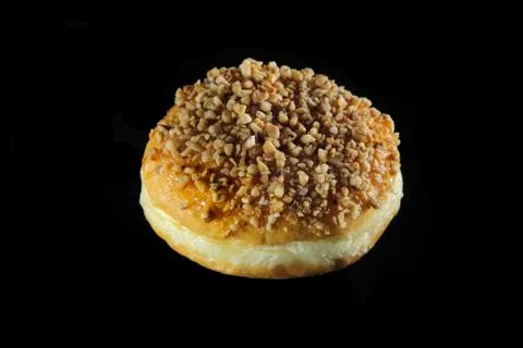 Round doughnut with nuts on black background Stock Photos
