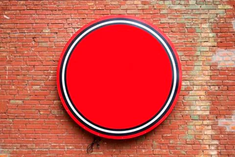 Round empty red banner hanging on a brick wall Stock Photos