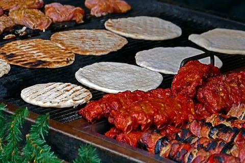 Round flat bread, meat and skewers, cooked on the grill Stock Photos