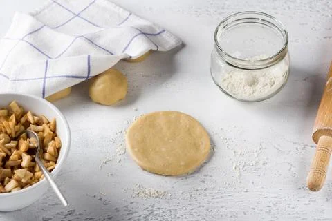 Round flat piece of rolled out dough, apple filling with cinnamon, flour an.. Stock Photos