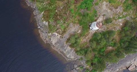 Round flight over lighthouse on rocky cape to huge lake  스톡 동영상 100982317