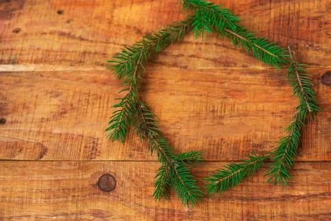 A round frame of Christmas tree branches on a wooden background. New Year's.. Stock Photos