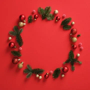 Round frame of fir branches, pinecones, red berries and red and gold bauble.. Stock Photos