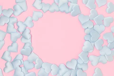 Round frame made of blue textile confetti in a heart shape on a pink backgr.. Stock Photos