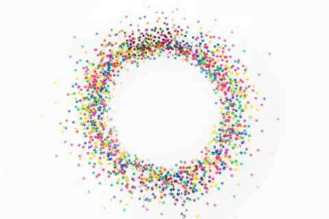Round frame made of colored confetti stars. White background. Festive confetti. Stock Photos