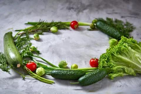 The round frame made of vegetables and herbs on a white textured background Stock Photos