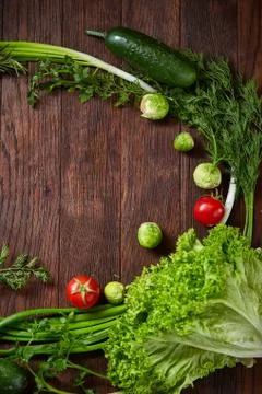 The round frame made of vegetables and herbs on a wooden background, copy space Stock Photos